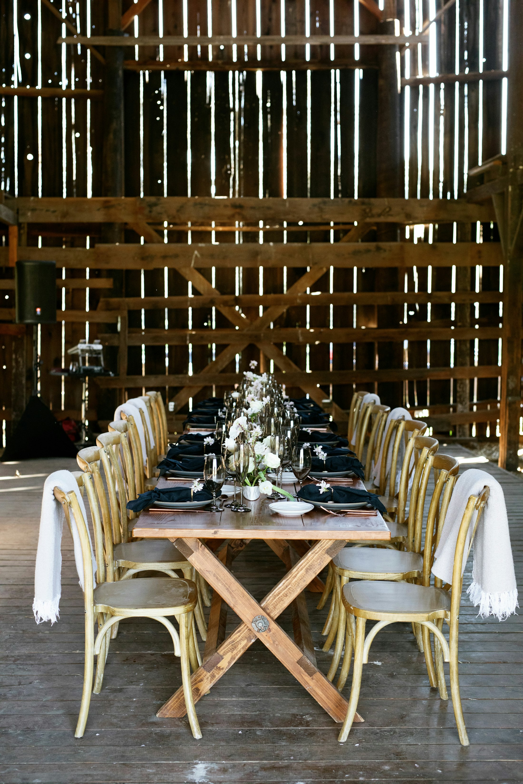 Rustic monochromatic tablescape inside of a historic barn
