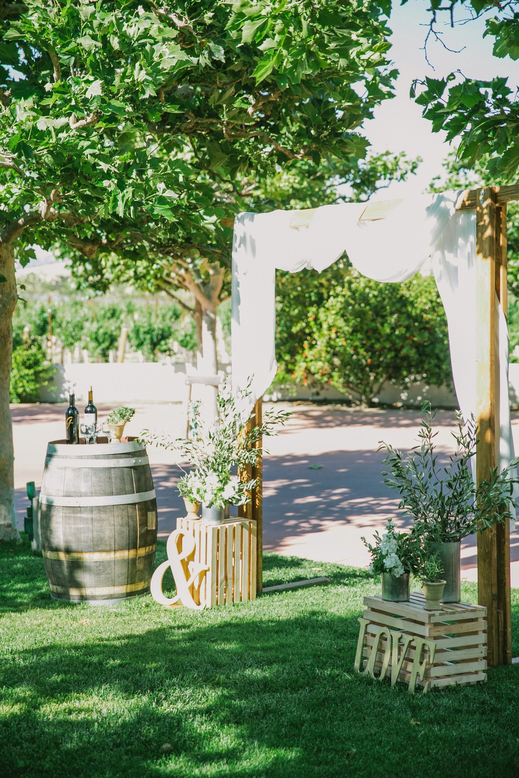 Wedding platform with wine bottles displayed on a barrel